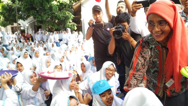 Menteri Kelautan dan Perikanan Susi Pudjiastuti membagikan ikan kepada santriwati di Pondok Pesantren Darussalam Banyuwangi, Sabtu (3/11/2018). (Foto: Muhammad Miradi/kumparan)