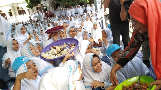 Menteri Kelautan dan Perikanan Susi Pudjiastuti membagikan ikan kepada santriwati di Pondok Pesantren Darussalam Banyuwangi, Sabtu (3/11/2018). (Foto: Muhammad Miradi/kumparan)
