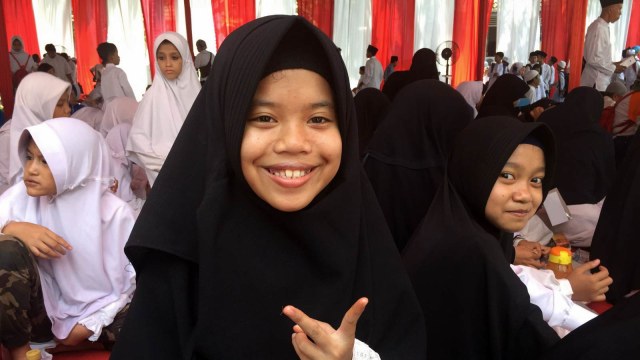 Santriwati di Pasuruan, Jawa Timur,  yang disuapi ikan oleh Menteri Susi.
 (Foto: Rizki Baiquni/kumparan)