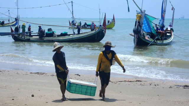Nelayan membawa ikan teri tangkapannya ketika pulang melaut di Pantai Jumiang, Pamekasan, Jawa Timur. (Foto: ANTARA FOTO/Saiful Bahri)