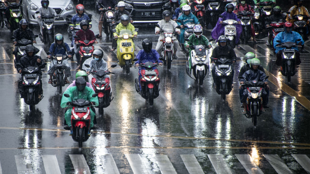 Pengendara sepeda motor menggunakan mantel saat hujan. (Foto: ANTARA FOTO/Aprillio Akbar)