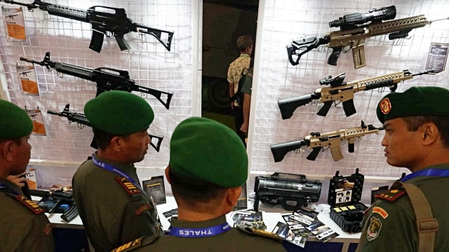 Pengunjung melihat miniatur senapan dalam acara pameran Indo Defence Expo & Forum di Jiexpo Kemayoran  Jakarta, Jumat (9/11/2018). (Foto: Jamal Ramadhan/kumparan)