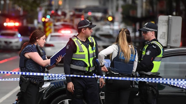 Seorang petugas berjaga di garis polisi saat terjadinya penusukan di Melbourne, Australia. (Foto: AFP/WILLIAM WEST)