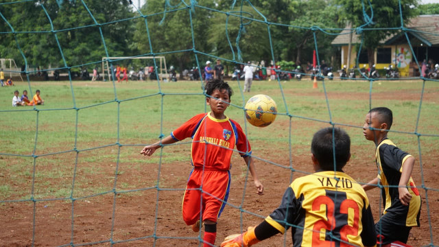 Sejumlah anak-anak berlatih sepak bola dan melakukan latihan tanding di lapangan kawasan Condet, Jakarta Timur. (Foto: Iqbal Firdaus/kumparan)