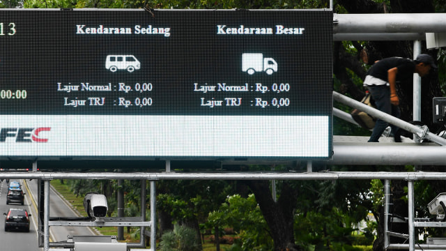 Petugas mengontrol alat teknologi sistem jalan berbayar elektronik (ERP) di Jalan Merdeka Barat. Foto: ANTARA FOTO/Wahyu Putro A