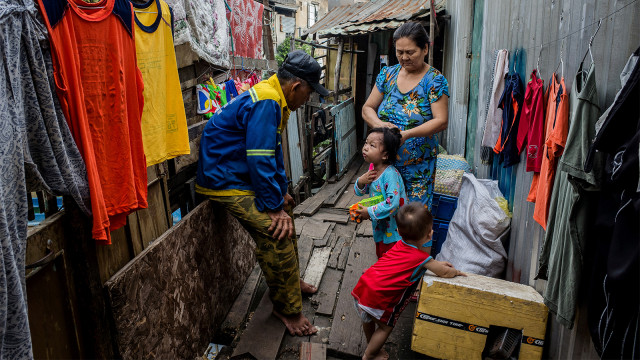 Le Ngoc Chau (kiri) menyapa cucunya di kawasan padat penduduk di sepanjang kanal Xuyen Tam di Kota Ho Chi Minh. (Foto: Kao Nguyen / AFP)