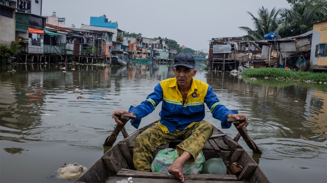 Le Ngoc Chau menggunakan sampannya melintasi kanal Xuyen Tam di Kota Ho Chi Minh yang semakin sempit. (Foto: Kao Nguyen / AFP)