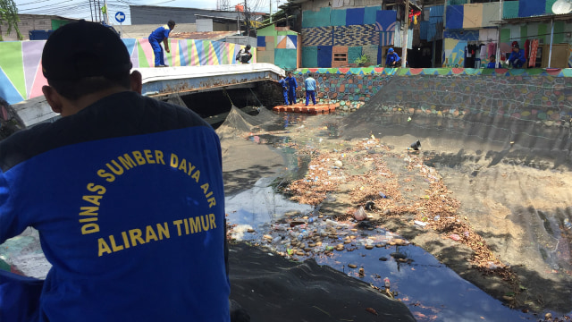 Petugas Sumber Daya Air (SDA) Jakarta mencopot jaring kali Item. (Foto: Fachrul Irwinsyah/kumparan)