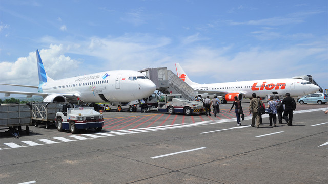 Pesawat Garuda dan pesawat Lion Air di landasan bandara Bali. (Foto: AFP / Romeo Gacad)