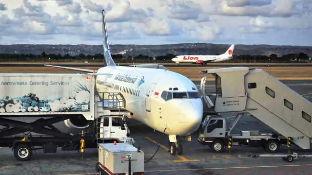 Pesawat Garuda dan pesawat Lion Air di landasan bandara Bali. (Foto: AFP / Bay Ismoyo)