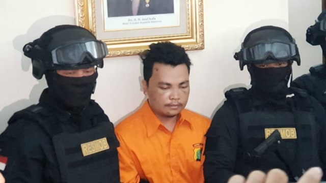 Haris Simamora, pelaku pembunuhan 1 keluarga di Pondok Gede, dihadirkan saat jumpa pers di Polda Metro Jaya. (Foto: Fadjar Hadi/kumparan)