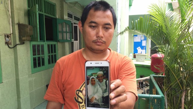 Adik Dufi, Muhammad Ali Ramdoni, menunjukkan foto Dufi dan istrinya. (Foto: Fachrul Irwinsyah/kumparan)