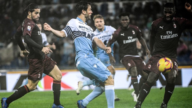 Duel antara Marco Parolo dan Cristian Zapata. Foto: Filippo MONTEFORTE / AFP