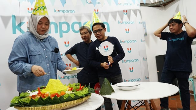 Direktur Operasional, Ine Yordenaya (kiri), melakukan pemotongan tumpeng dalam acara syukuran kantor baru kumparan di kawasan Pasar Minggu. (Foto: Jamal Ramadhan/kumparan)