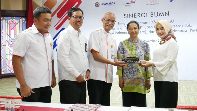 Pemberian cenderamata oleh Pertamina kepada Pos Indonesia sebagai bentuk kerja sama. (Foto: Dok. Kementerian BUMN)
