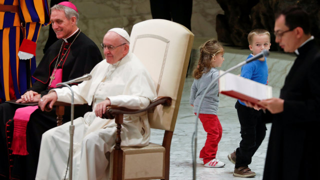 Seorang anak mengganggu ceramah Paus Fransiskus di ruang Paulus VI di Vatikan. (Foto: REUTERS/Max Rossi)
