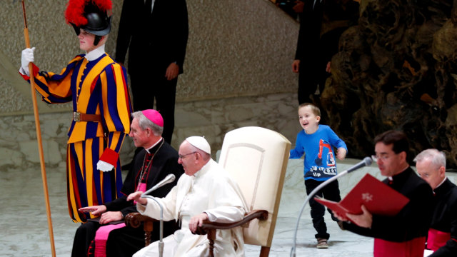Seorang anak mengganggu ceramah Paus Fransiskus di ruang Paulus VI di Vatikan. (Foto: REUTERS/Max Rossi)