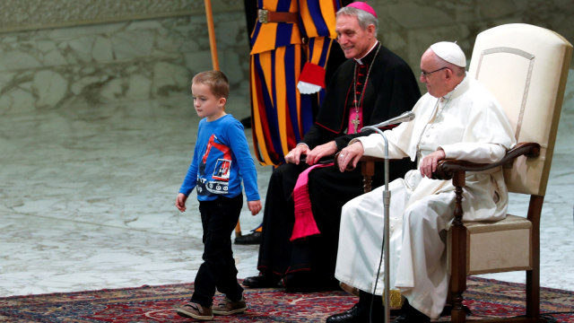 Seorang anak mengganggu ceramah Paus Fransiskus di ruang Paulus VI di Vatikan. (Foto: REUTERS/Max Rossi)