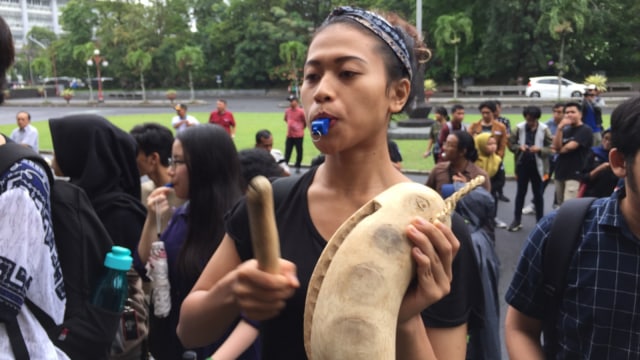 Puluhan mahasiwa datang dengan meniup peluit dan kentongan sebagai tanda bahaya bahwa kasus pelecehan seksual dan kekerasan seksual masih ada di UGM.  (Foto: Arfiansyah Panji Purnandaru/kumparan)