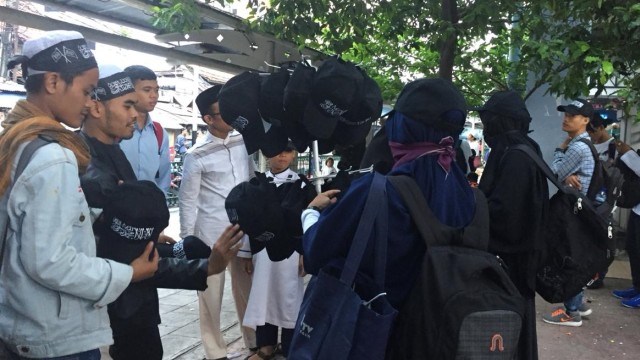 Peserta Reuni 212 berburu atribut di kawasan Monas, Jakarta. (Foto: Nesia Qurrota/kumparan)