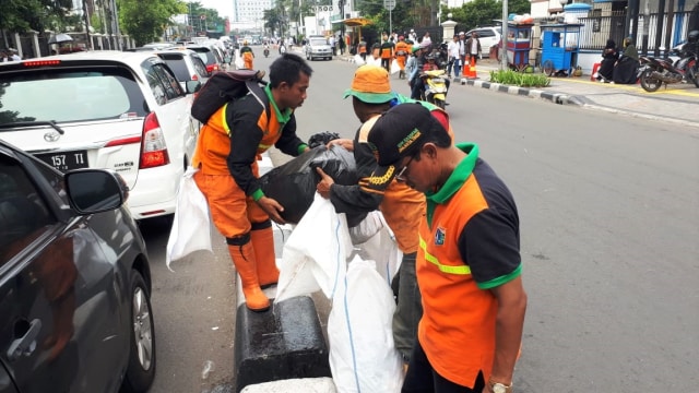 Dinas Lingkuhan Hidup DKI Jakarta bersama Pengelola Monas membersihkan sampah usai Aksi Reuni 212. (Foto: Dok. Dinas Lingkungan Hidup DKI)