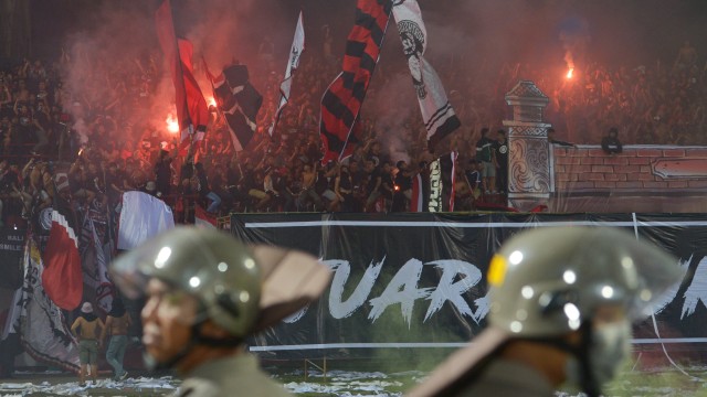 Pendukung klub Bali United menyalakan kembang api ketika berlangsungnya pertandingan Sepak Bola Liga 1 antara Bali United melawan Persija Jakarta di Stadion I Wayan Dipta, Gianyar, Bali, Minggu (02/12/2018). Persija Jakarta menang atas Bali United dengan skor 2-1 setelah beberapa kali pertandingan sempat dihentikan karena ulah penonton.  (Foto: ANTARA FOTO/Nyoman Budhiana)