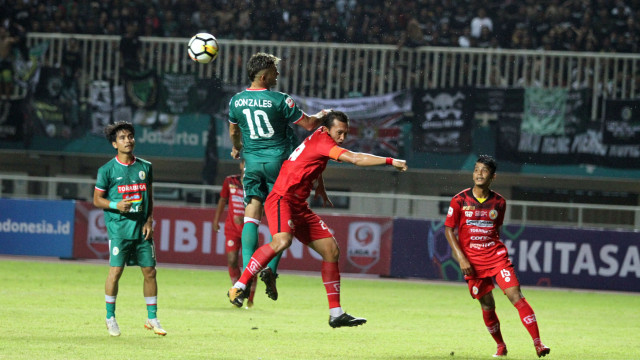 Cristian Gonzales (kiri) berduel dengan pemain Semen Padang, Wahyu Trisnajaya. (Foto: Antara/Yulius Satria Wijaya)