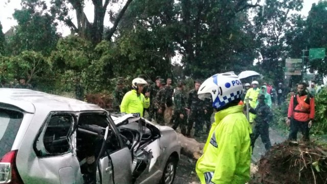 Sejumlah anggota polisi Polresta Kota Bogor membantu membersihkan batang pohon yang hancur akibat puting beliung di kota Bogor. (Foto: Dok. Polresta Kota Bogor)