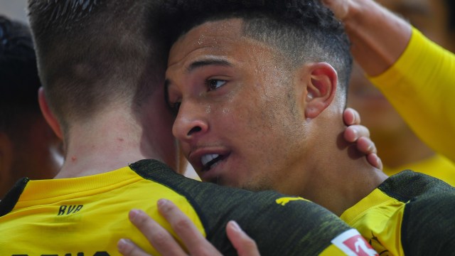 Jadon Sancho dipeluk kapten Dortmund, Marco Reus. Foto: Patrik STOLLARZ / AFP