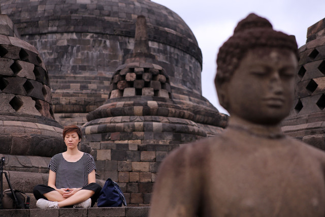 Seorang pengunjung yang sedang bermeditasi di Candi Borobudur (Foto: Aria Sankhyaadi/kumparan)