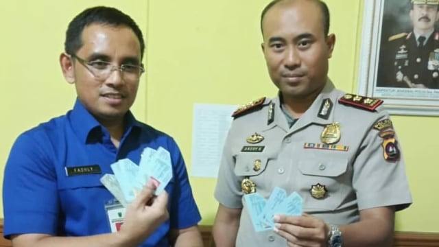 Kapolres Pariaman memegang e-KTP yang ditemukan dalam karung. (Foto: Istimewa)