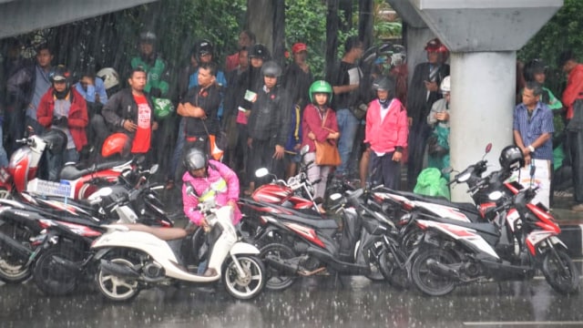 Suasana Jalan Gatot Subroto ketika dilanda hujan, pengendara motor berteduh di bawah JPO. Foto: Iqbal Firdaus/kumparan
