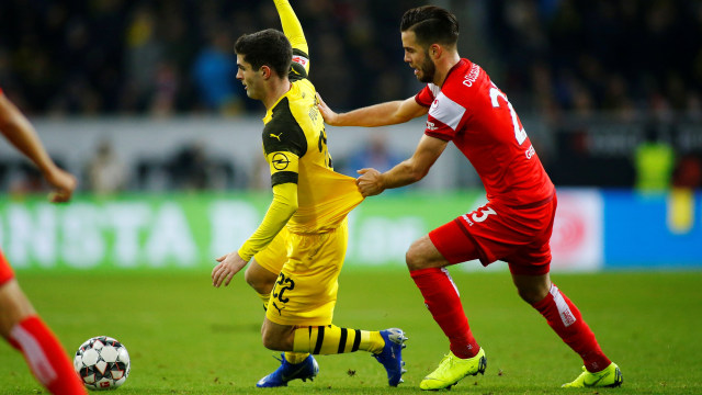 Niko Giesselmann (kiri) berusaha menghentikan Christian Pulisic. (Foto: REUTERS/Thilo Schmuelgen)