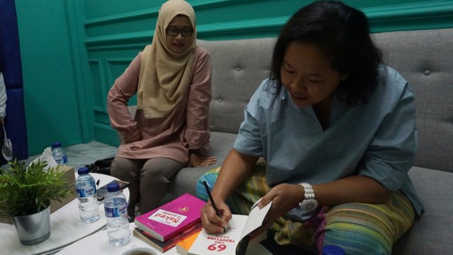 Trinity menandatangani buku ciptaannya di kantor kumparan. (Foto: Fitra Andrianto/kumparan)