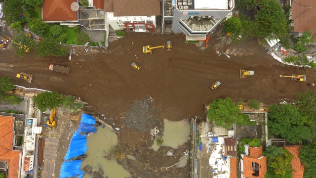 Foto aerial sejumlah alat berat meratakan urukan di lokasi jalan ambles di Jalan Raya Gubeng, Surabaya, Jawa Timur, Minggu (23/12/2018). Foto: ANTARA FOTO/Didik Suhartono