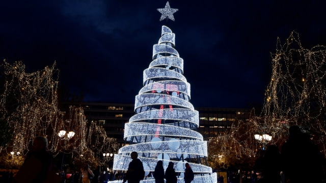 Sejumlah orang berjalan di depan hiasan Natal di Athena. (Foto: AFP/LOUISA GOULIAMAKI)