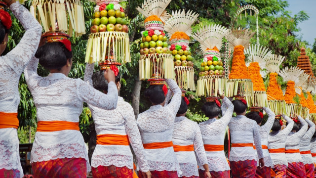 Para wanita memakai baju putih dan membawa sesajen pada Hari Raya Galungan dan Kuningan Foto: Shutter Stock
