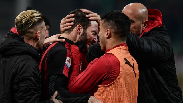 Higuain merayakan golnya bersama pemain-pemain Milan di laga vs SPAL. (Foto: Marco BERTORELLO / AFP)