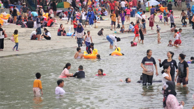 Ribuan pengunjung bermain dan berenang di Pantai Karnaval Ancol dan sekitarnya sejak sore hari, Senin (31/12). (Foto: Nugroho Sejati/kumparan)