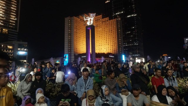 Warga memadati kawasan Bundaran Hotel Indonesia jelang malam pergantian tahun baru 2019, Jakarta, Senin (31/12). Hujan tak mengurungkan niat warga untuk menyambut malam tahun baru di kawasan Bundaran HI. Foto: Fanny Kusumawardhani/kumparan