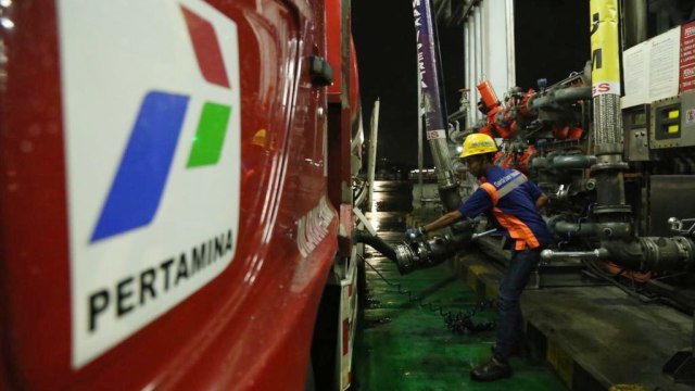 Salah satu awak mobil tangki tangki (AMT) Pertamina sedang melakukan pengisian BBM Pertamax untuk didistribusikan ke SPBU setempat menjelang menjelang malam pergantian tahun baru 2019 Foto: Pertamina