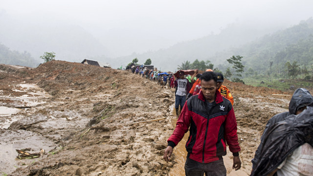 Petugas dan warga meninggalkan area longsor saat di guyur hujan di kampung Cimapag, Desa Sirnaresmi, Kecamatan Cisolok, Kabupaten Sukabumi. (Foto: Antara/Agung Rajasa)