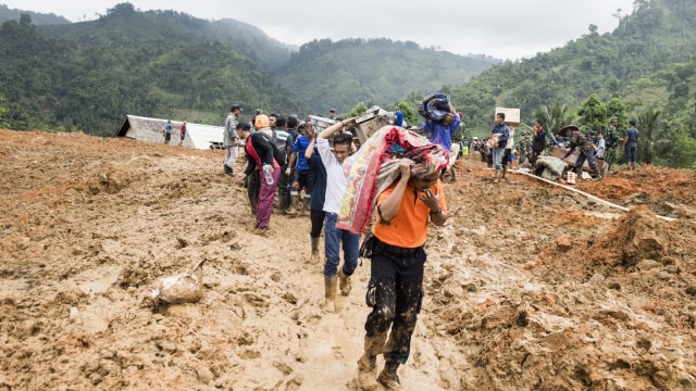 Warga membawa barang yang tersisa dari reruntuhan longsor di kampung Cimapag, Desa Sirnaresmi, Kecamatan Cisolok, Kabupaten Sukabumi. (Foto: Antara/Agung Rajasa)