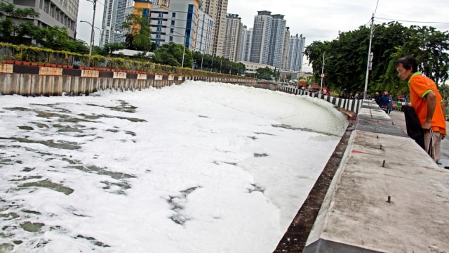 Warga melihat kumpulan busa yang memenuhi Kali Item di Kawasan Kemayoran, Jakarta, Selasa (1/1/2019). (Foto: Antara/Galih Pradipta)
