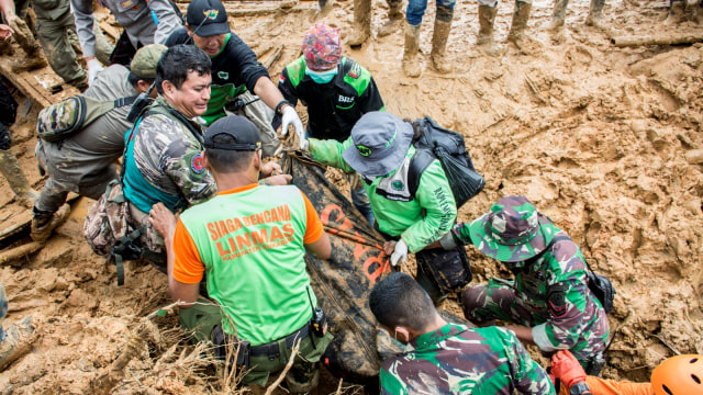 Petugas SAR gabungan mengangkat kantung jenazah pasca bencana tanah longsor di kampung adat Sinarresmi, Cisolok, Kabupaten Sukabumi, Jawa Barat, Selasa (1/1/2019).  (Foto: ANTARA FOTO/Nurul Ramadhan)