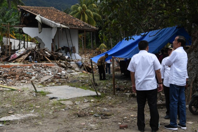 Presiden Joko Widodo (kanan) mengamati bangunan yang rusak akibat tsunami Selat Sunda di Desa Kunjir, Rajabasa Lampung Selatan, Lampung, Rabu (2/1/2019). (Foto: ANTARA FOTO/Wahyu Putro A)