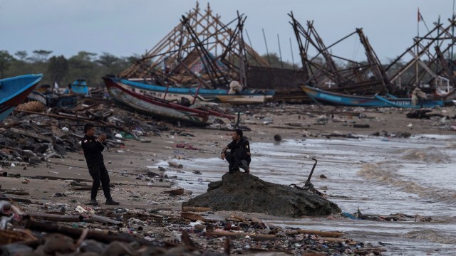 Warga memotret rekannya di antara puing-puing yang rusak karena tsunami Selat Sunda di Sumur, Pandeglang, Banten, Kamis (3/1).  (Foto: ANTARA FOTO/Sigid Kurniawan)