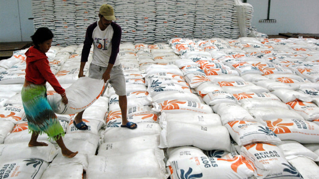 Pekerja mengangkat karung isi beras di Gudang Beras Bulog. (Foto: ANTARA FOTO/Abriawan Abhe)