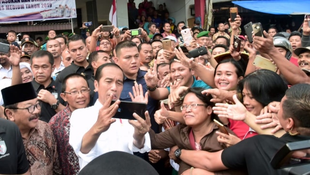 Presiden Joko Widodo berswafoto dengan pengunjung dan pedagang di Pasar Grosir Ngemplak di Desa Botoran, Kabupaten Tulungagung, Jawa Timur. (Foto: Biro Pers Sekretariat Presiden/Muchlis Jr)