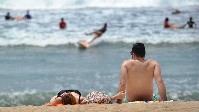 Turis berlibur di Pantai Kuta, Bali, Jum'at (4/1/2019).
 Foto: AFP/SONNY TUMBELAKA